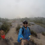 A selfie taken during a trek in Canaima, Venezuela, showing rain starting to fall, small water streams forming, and wet hikers on the trail