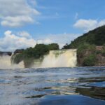 A powerful waterfall with roaring water, photographed from a boat on the river in Canaima, Venezuela
