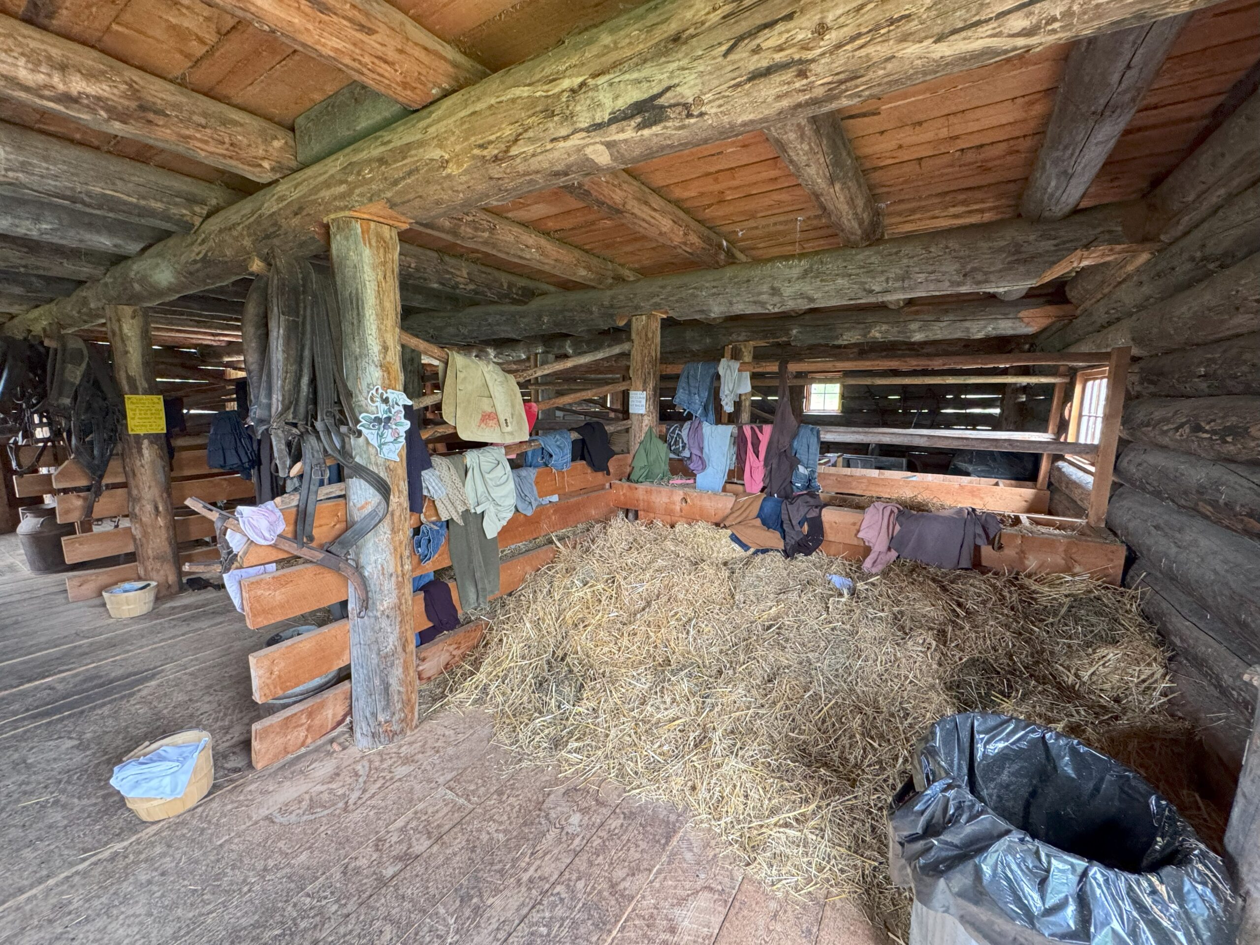 Interior of the barn at Huble Homestead with vintage tools, work clothes, and farming equipment.