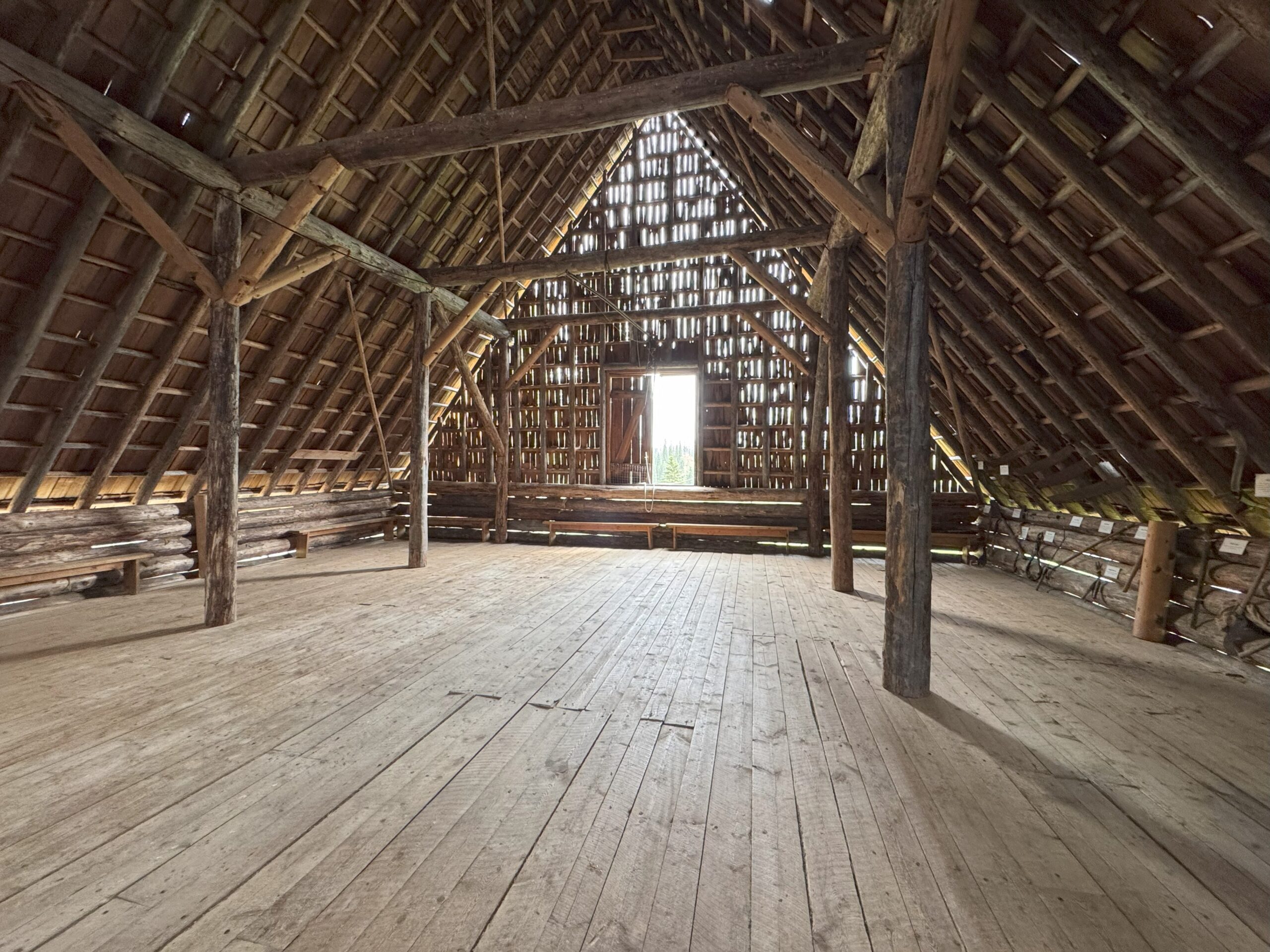 The hayloft on the second floor of the Huble Homestead barn, with hay bales and wooden beams.