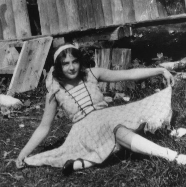 Black and white photo of Bertha Bernice wearing a beautiful dress, sitting on the grass.
