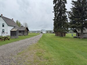 Scenic view of Huble Homestead showing historic buildings, open grounds, and surrounding natural landscape beyond the main entrance.