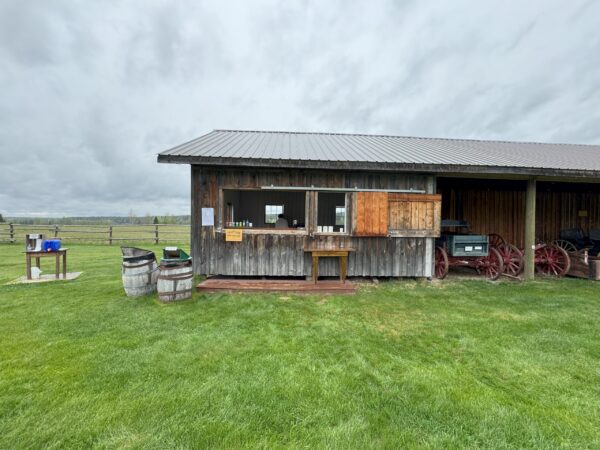 People preparing food inside a wooden, single-story building