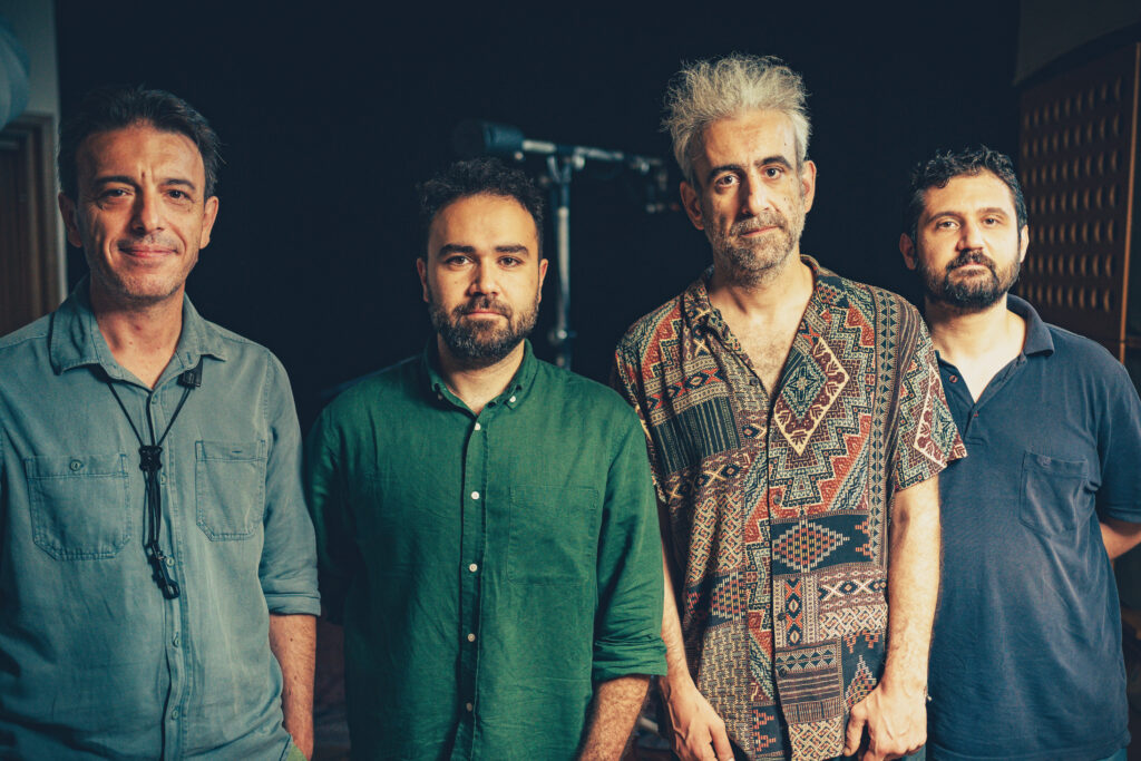 Zenith - Tamer Temel, Barış Arslan, Apostolos Sideris, Efe Oğur Tamer Temel, Barış Arslan, Apostolos Sideris, and Efe Oğur stand side by side in a recording studio, posing for a group photo.