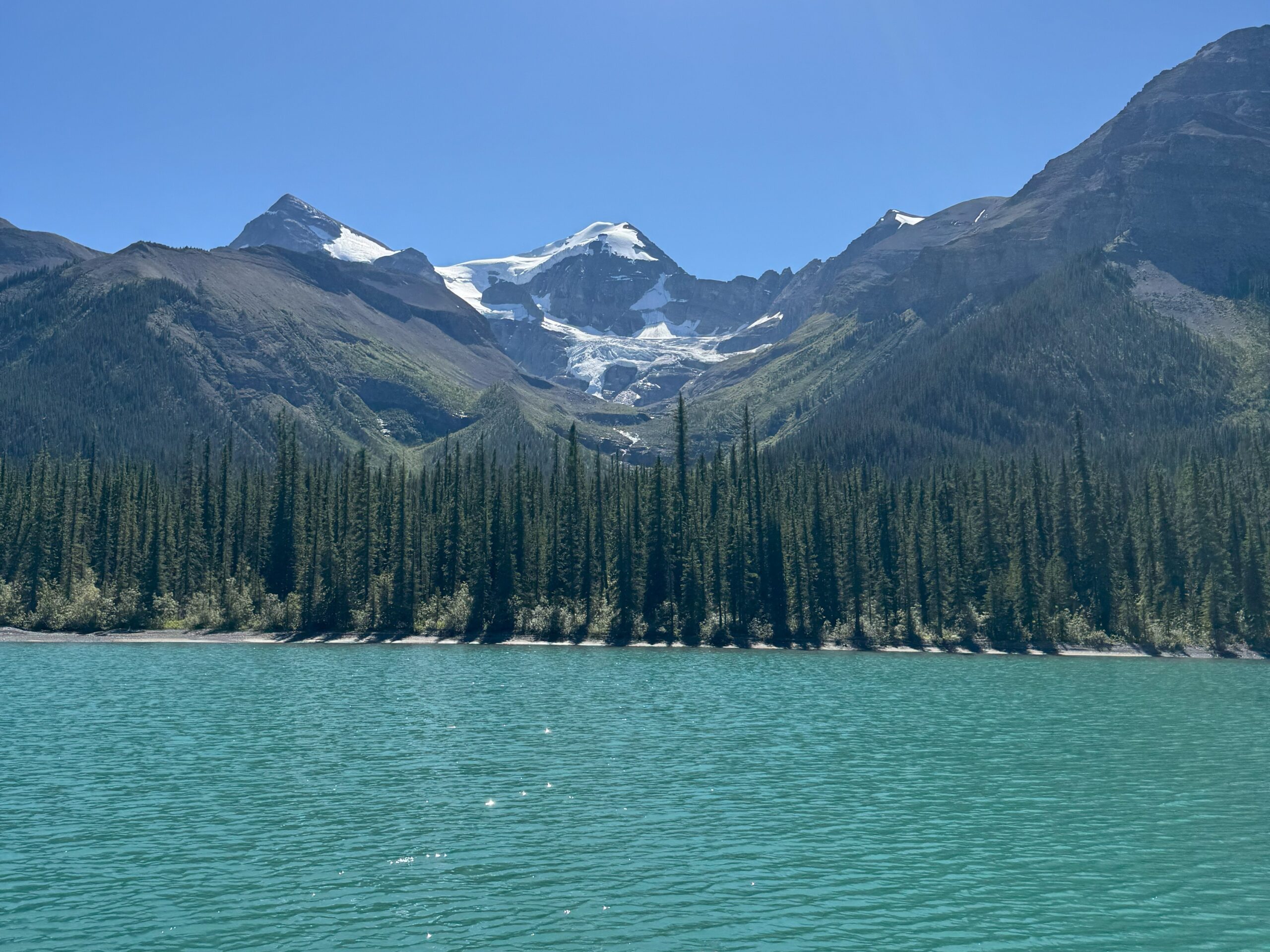 Stunning view of turquoise waters and glacier-capped mountains at Maligne Lake in Jasper National Park, Alberta, Canada.