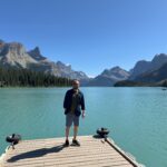 Traveler standing on Spirit Island with Maligne Lake and the Rocky Mountains in the background, Jasper National Park.