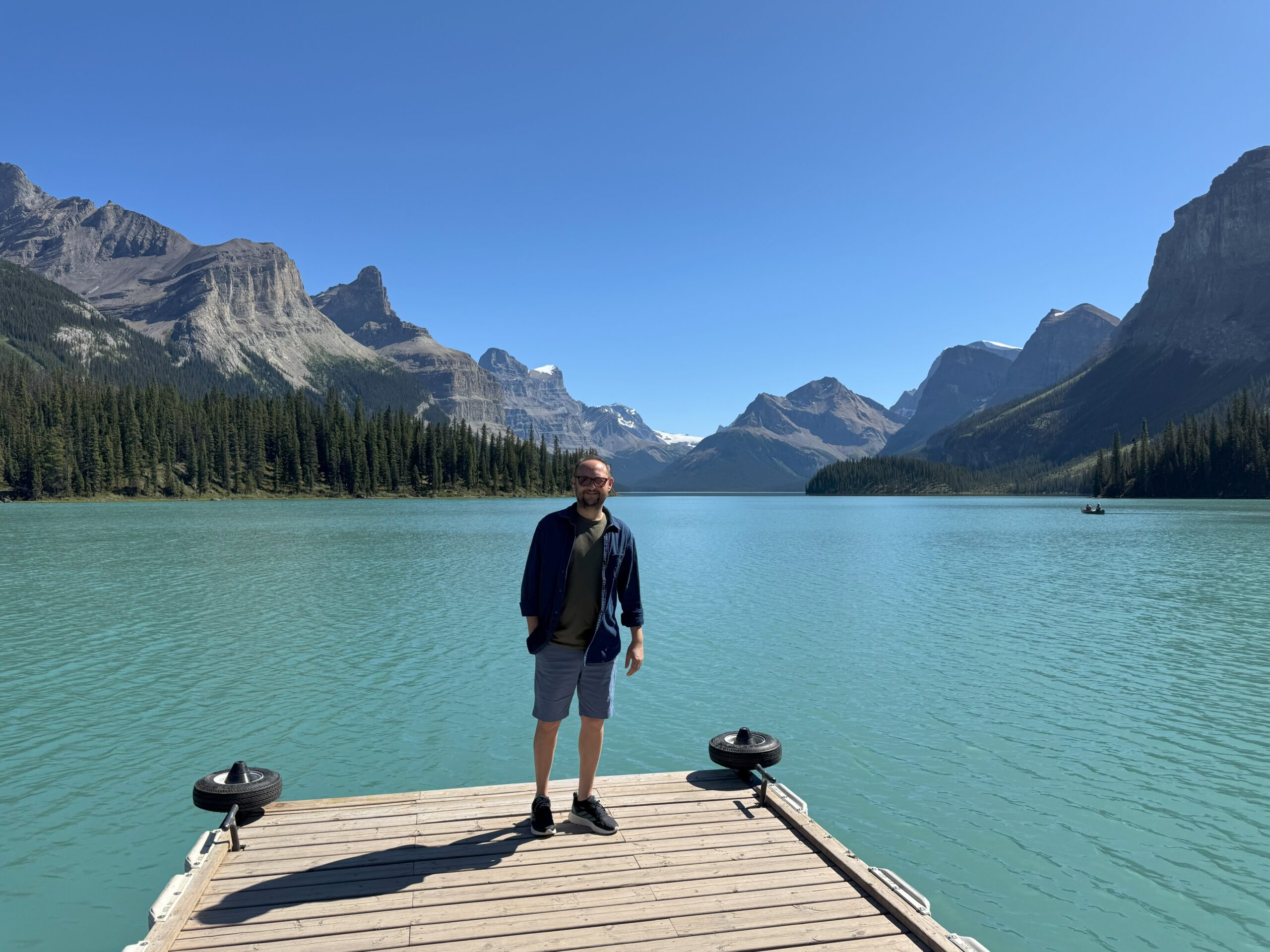 Traveler standing on Spirit Island with Maligne Lake and the Rocky Mountains in the background, Jasper National Park.
