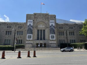 Front view of the Royal Ontario Museum in Toronto, with banners advertising the “Auschwitz. Not long ago. Not far away.” exhibition.