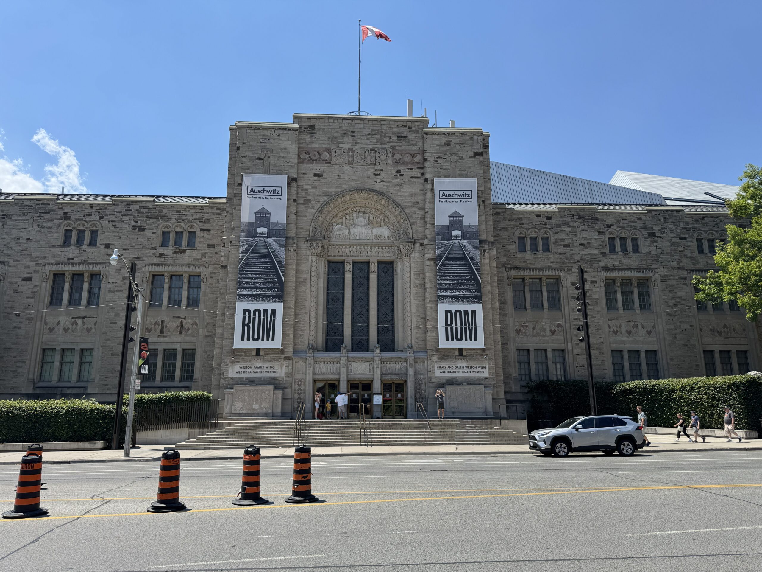 Front view of the Royal Ontario Museum in Toronto, with banners advertising the “Auschwitz. Not long ago. Not far away.” exhibition.