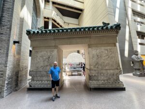 A visitor stands beside an ancient Chinese stone gate inside the Royal Ontario Museum in Toronto.