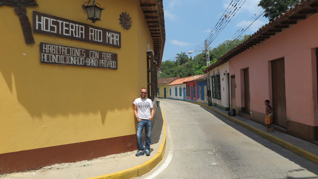 Venezuela'nın Karayip kıyısındaki Choroni'de, renkli sömürge evlerinin ve bir pansiyon tabelasının bulunduğu sakin bir sokak.