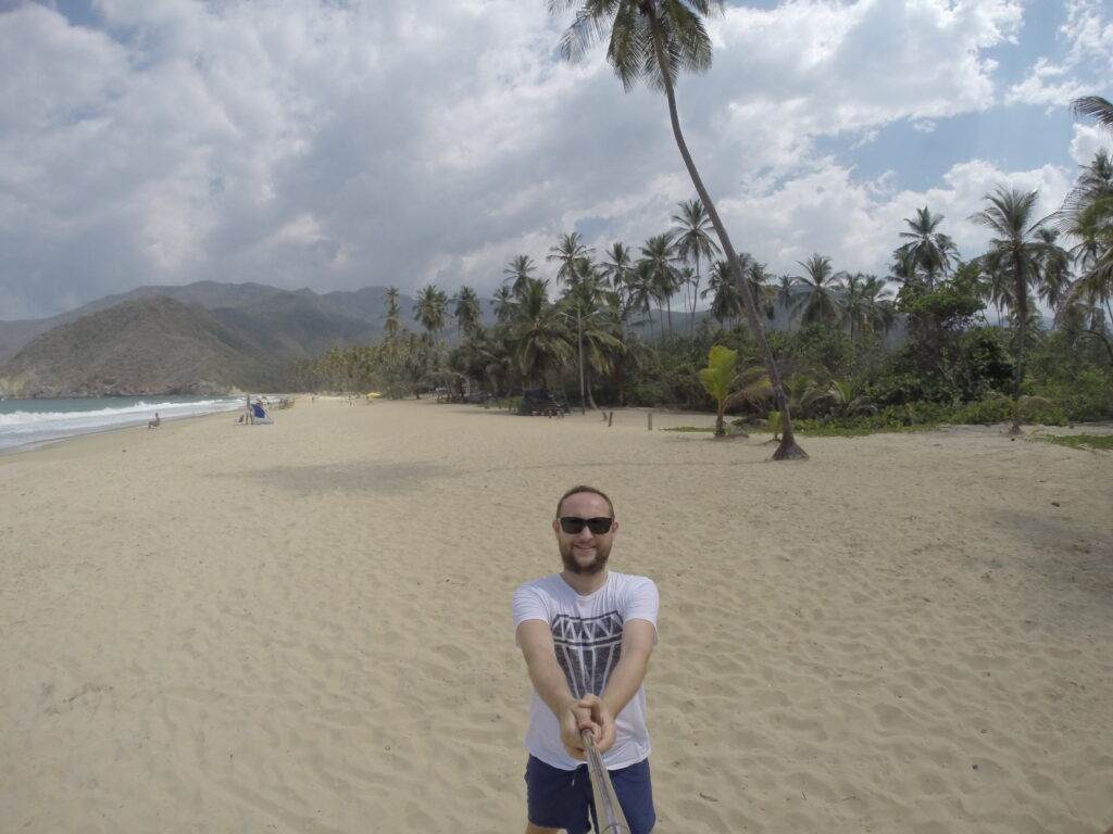 Choroni, Venezuela’daki Playa Grande’de palmiye ağaçları ve dağ manzarasıyla geniş kumsal.