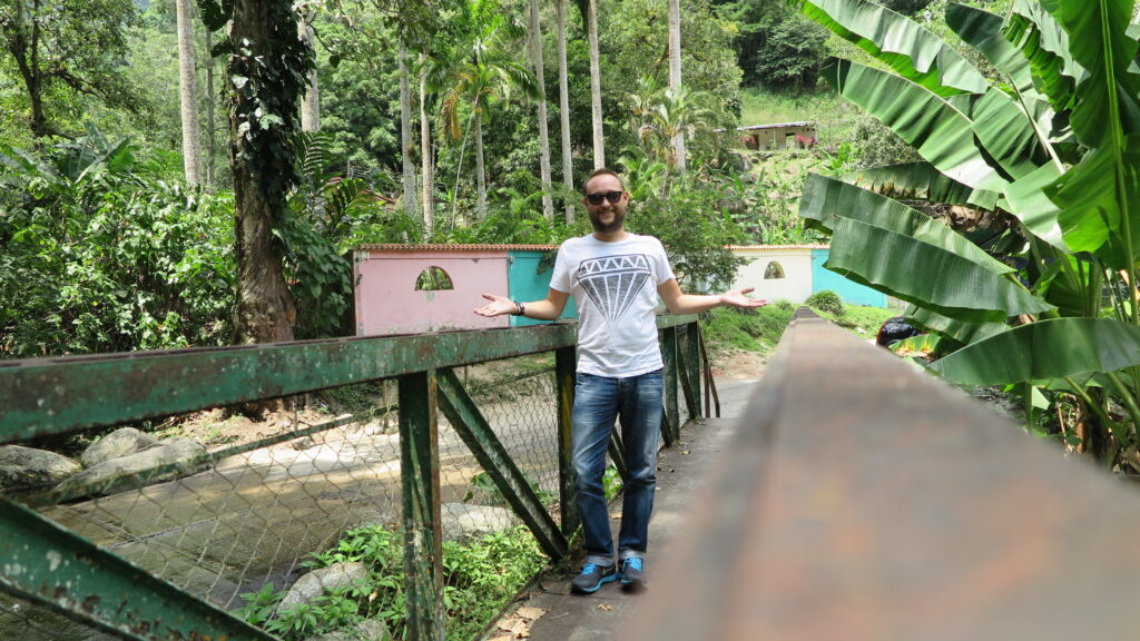 Choroni, Venezuela’da tropik bitki örtüsüyle çevrili küçük bir köprü üzerinde duran bir gezgin.