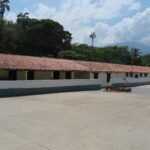 Venezuela'nın Chuao köyünde, dünyaca ünlü kakao çekirdeklerini saklamak için kullanılan, kurutma meydanının yanındaki kırmızı kiremit çatılı geleneksel kolonyal depolama binaları.