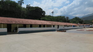 Venezuela'nın Chuao köyünde, dünyaca ünlü kakao çekirdeklerini saklamak için kullanılan, kurutma meydanının yanındaki kırmızı kiremit çatılı geleneksel kolonyal depolama binaları.