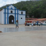 Chuao'da yaklaşan yağmurdan korumak için kilise meydanındaki kakao çekirdeklerini hızlıca toplayan yerel işçiler.