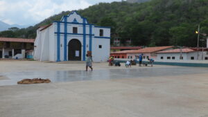 Chuao'da yaklaşan yağmurdan korumak için kilise meydanındaki kakao çekirdeklerini hızlıca toplayan yerel işçiler.
