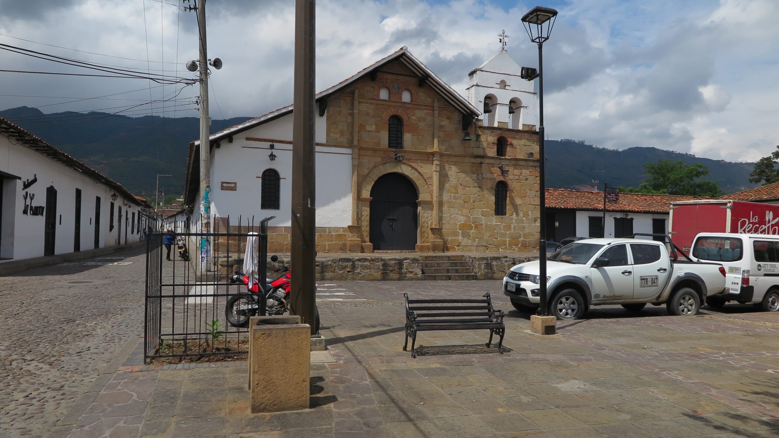 A historic colonial stone church in Girón with a white bell tower and a rustic facade.