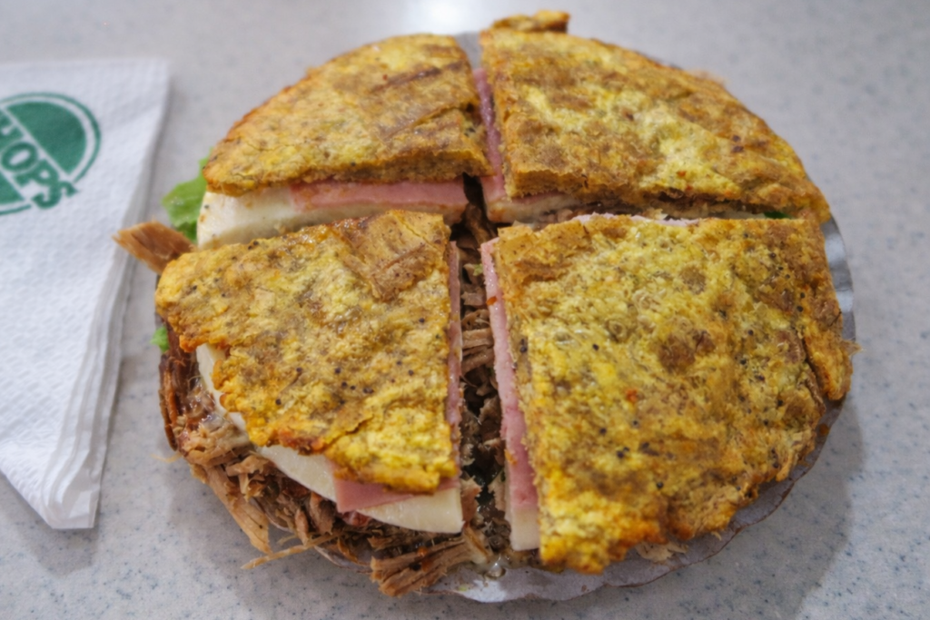 Kızartılmış yeşil muzdan yapılan Venezuelalı patacón sandvici; didiklenmiş et, jambon, erimiş peynir ve taze marul ile hazırlanmış.