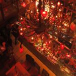 High-angle view of a crowded bar area in Andrés Carne de Res Bogota, featuring large red heart-shaped lanterns and an ornate chandelier.