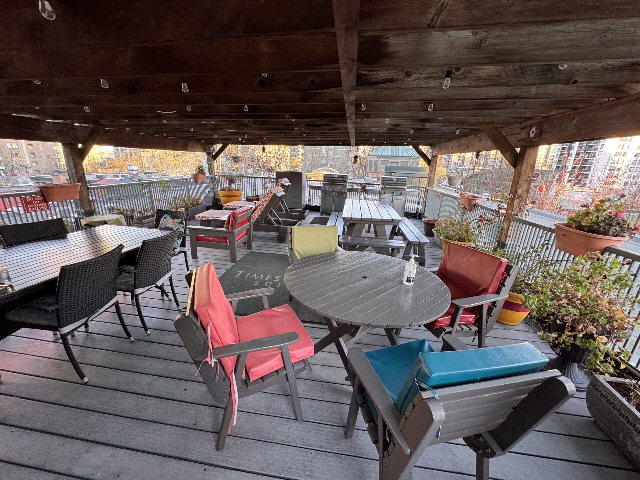 View from the rooftop patio of Times Square Suites Hotel in Vancouver’s West End, overlooking the intersection of Robson and Denman streets with city views.
