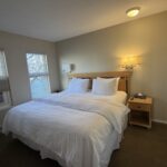 Cozy bedroom at Times Square Suites Hotel with crisp white linens and natural light.