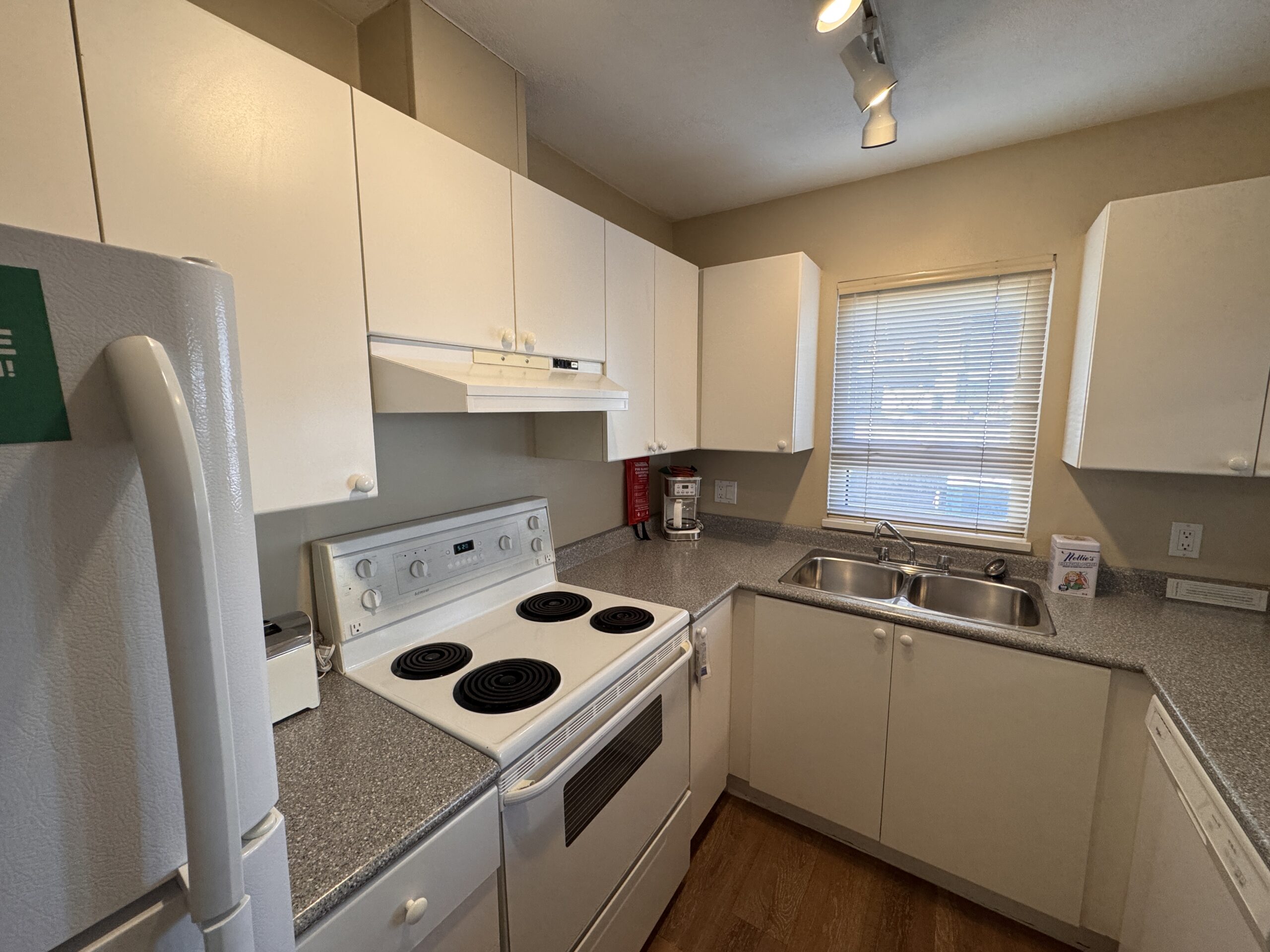 Fully equipped kitchen in a Times Square Suites Hotel suite, including a stove, microwave, and utensils.