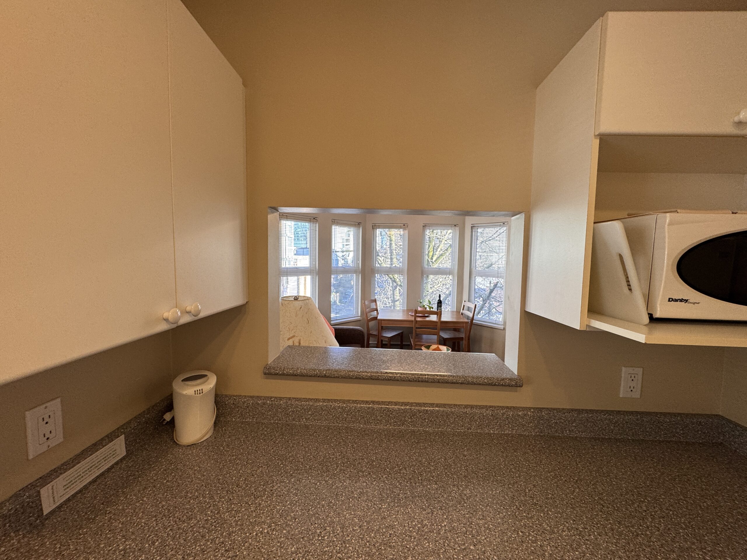 Fully equipped kitchen in a Times Square Suites Hotel suite, including a stove, microwave, and utensils.