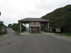 The main entrance gate and visitor center of the Cotacachi Cayapas Ecological Reserve in Ecuador, leading to Laguna de Cuicocha, with lush green mountains in the background.