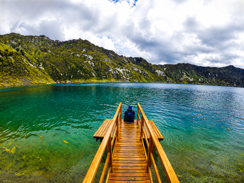 Ecuador Laguna de Quilotoa Lakeshore Wooden pier extending into the turquoise waters of Laguna de Quilotoa crater lake with the Andes Mountains in Ecuador