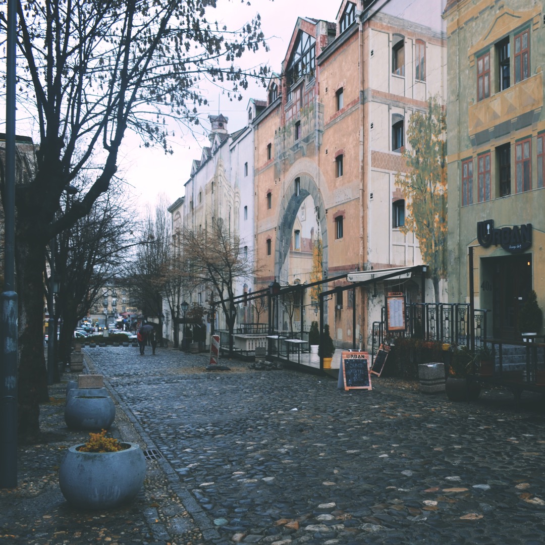 Things to do in Belgrade - Cobblestone street lined with painted historic buildings and cafes in the Skadarlija bohemian quarter of Belgrade, Serbia.