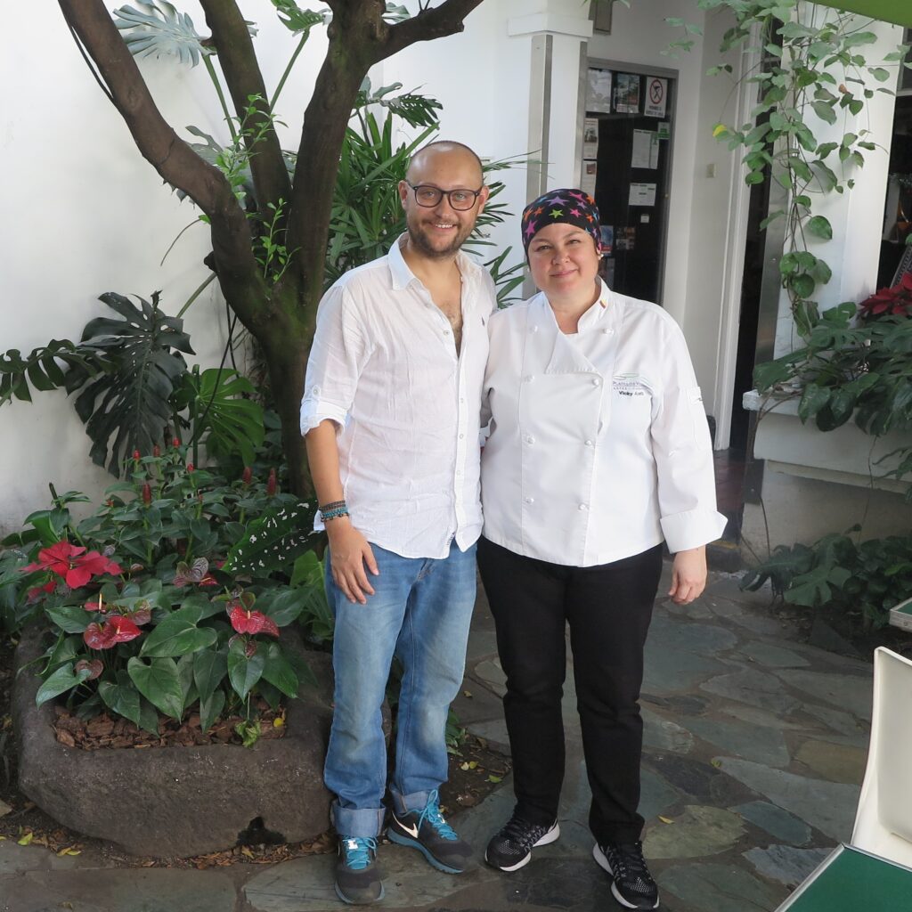 Chef Vicky Acosta Platillos Voladores Restaurant Cali Colombia Travel blogger Ismet Ersoy standing alongside acclaimed Colombian chef Vicky Acosta in the garden courtyard of Platillos Voladores Restaurant in Cali.