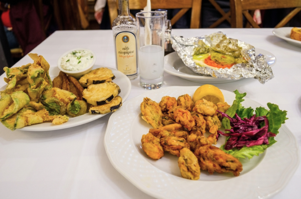 Savvas Seafood Restaurant Kavala Greece What to eat in Kavala - A spread of fresh Greek mezedes, fried seafood, and ouzo on a dining table at Savvas Seafood Restaurant in Kavala, Greece.