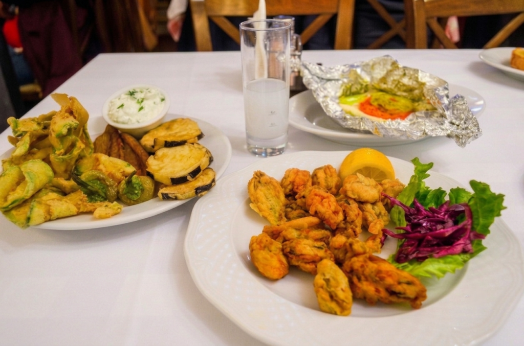 Savvas Restoran Kavala Yunanistan Kavala'da Nerede Ne Yenir? - Yunanistan Kavala'daki Savvas Restoranı'n masasında taze Yunan mezeleri, kızarmış deniz ürünleri ve uzo.