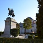 Things to do in Kavala - Bronze equestrian statue of Muhammad Ali Pasha on a high stone pedestal, with the Church of Panagia in the background in Kavala, Greece.