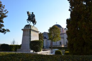 Things to do in Kavala - Bronze equestrian statue of Muhammad Ali Pasha on a high stone pedestal, with the Church of Panagia in the background in Kavala, Greece.
