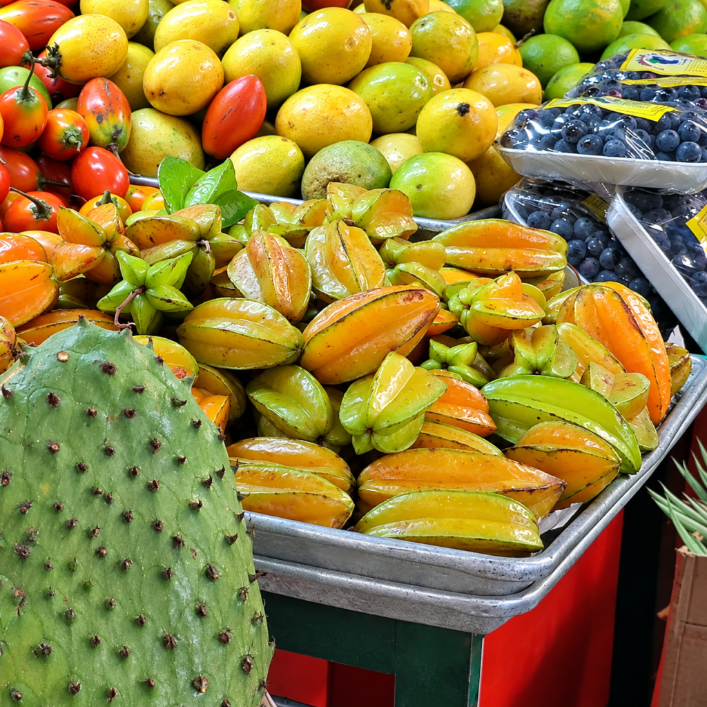 Colombia tropical fruits including fresh carambola (starfruit), citrus fruits, blueberries and cactus fruit at a local market.