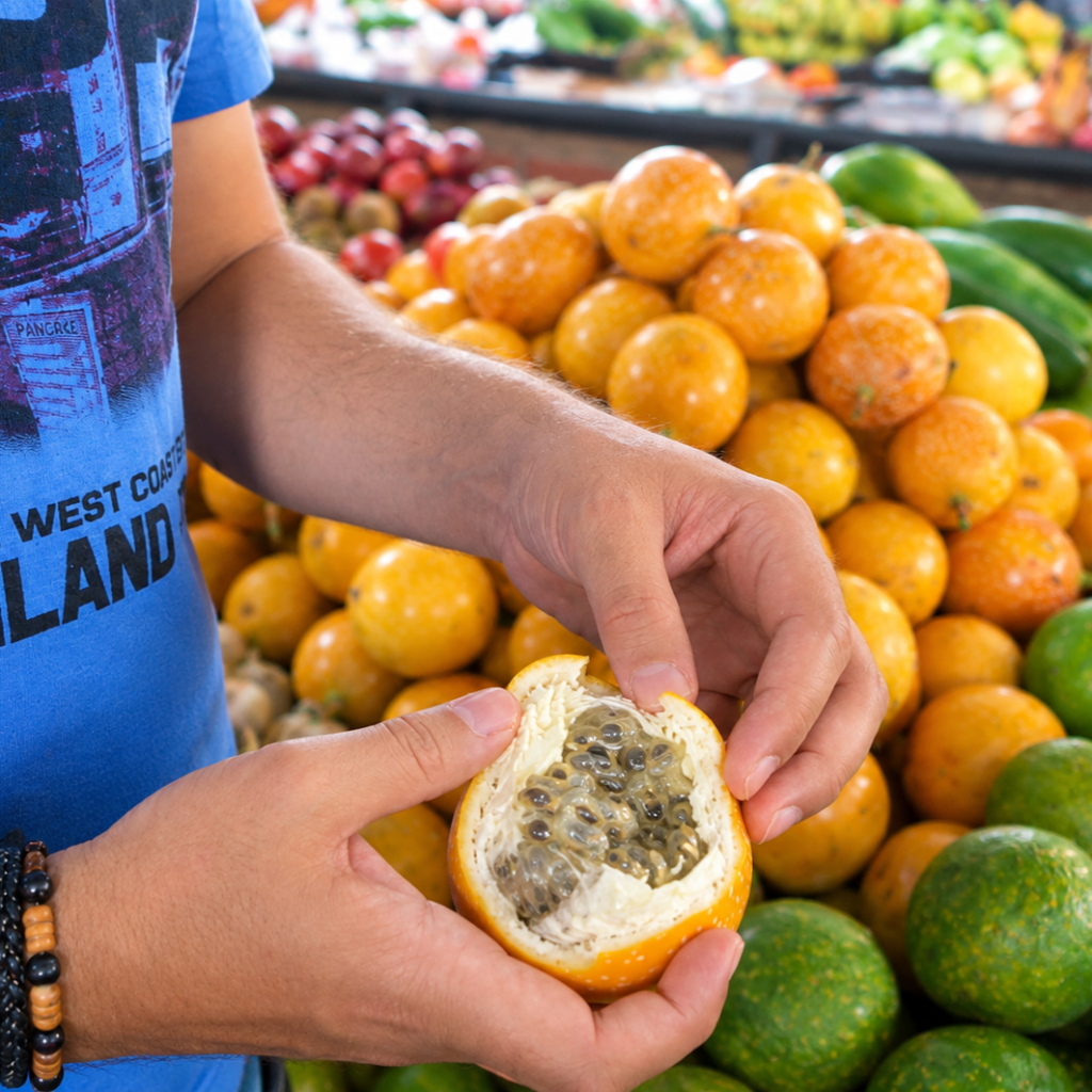Fresh granadilla fruit opened to reveal its juicy pulp and seeds at a Colombian market.